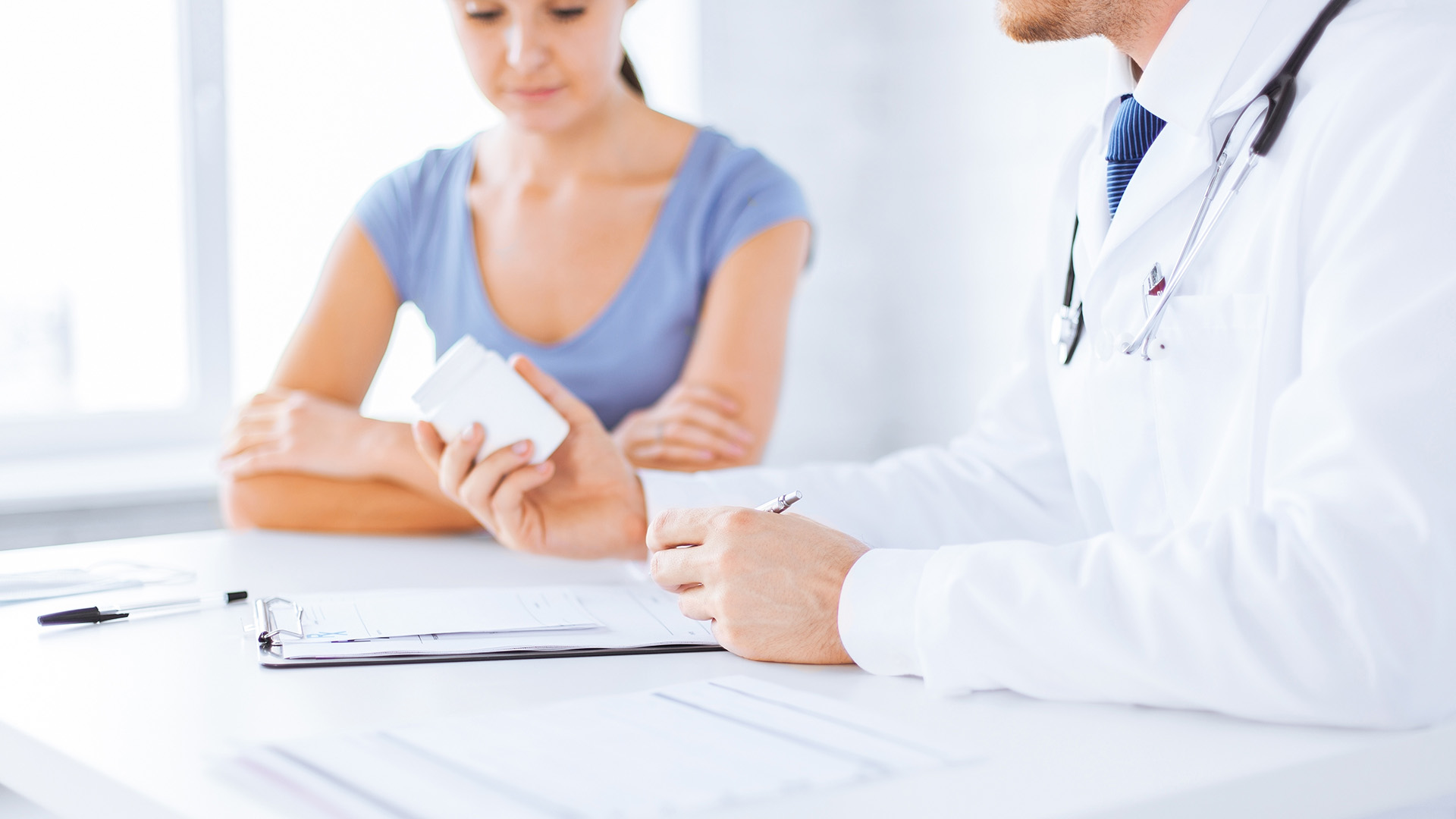 Close up of patient and doctor prescribing medication