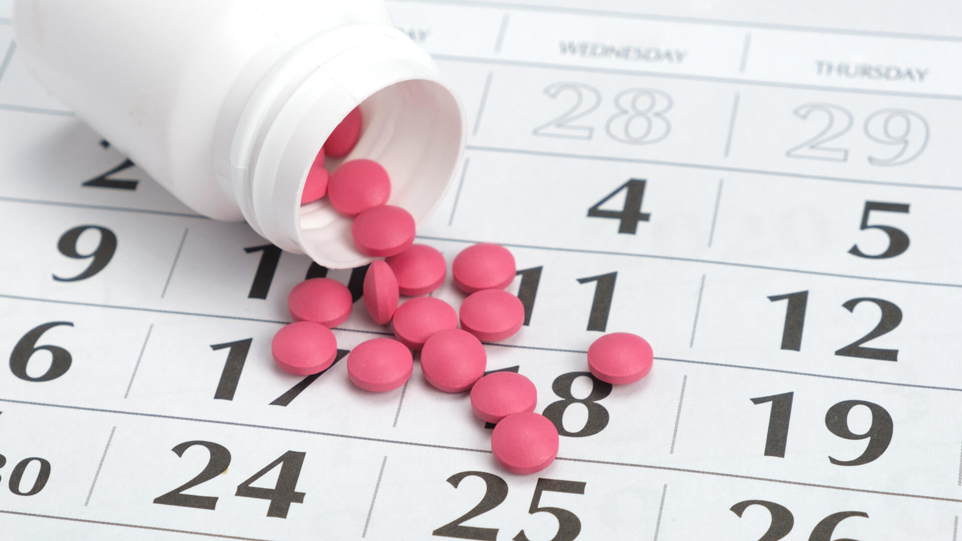 Prescription pills on a calendar background