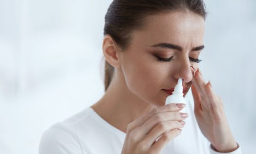 Cold. Beautiful Woman Using Nasal Spray